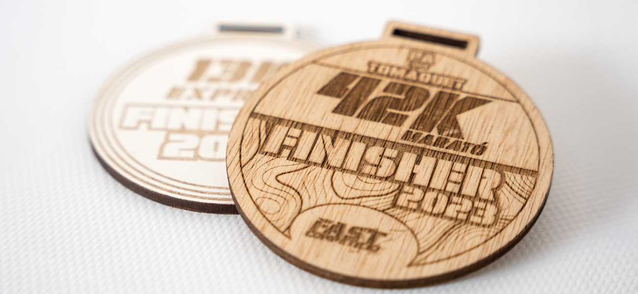 Medallas de madera grabadas con láser personalizables, ideales para reconocimientos únicos y memorables de la empresa Rotulpro. 
